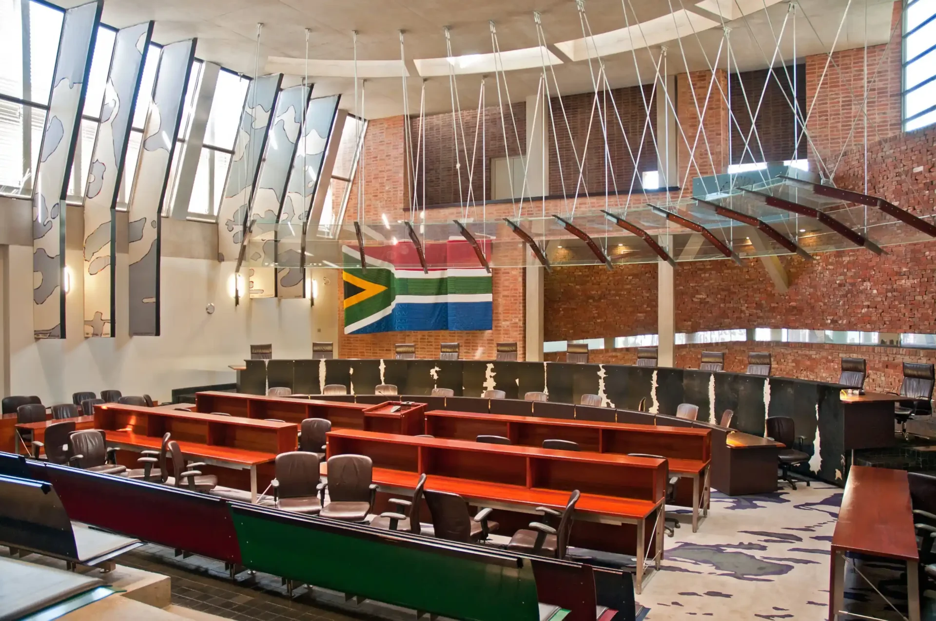 Courtroom with chairs and a South African Flag hanging on the wall in the background
